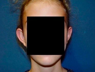 A young girl with a square in front of her face.