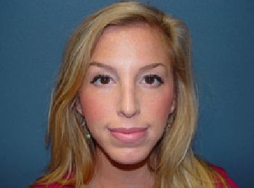 A close up of a woman 's face with a blue background.
