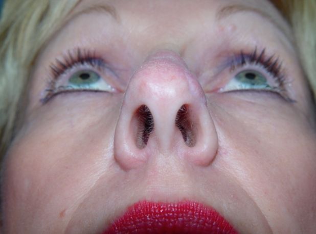 A close up of a woman 's nose with green eyes and red lips