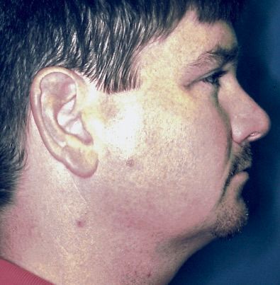 A close up of a man 's face with a red shirt on