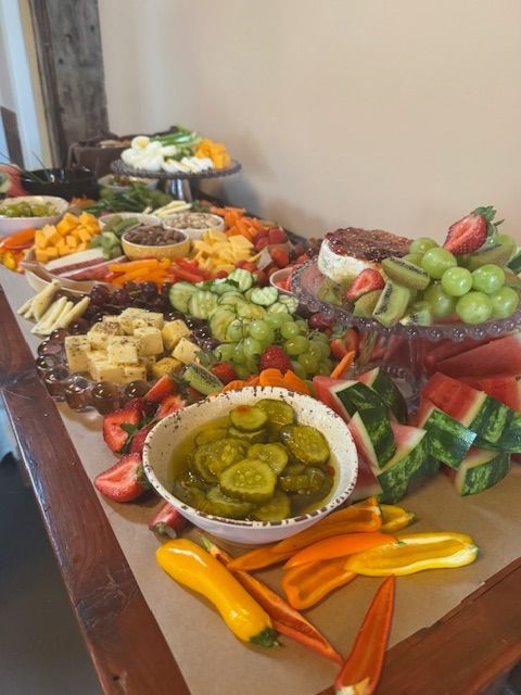 Colorful buffet table with fruit, pastries, pickles, and assorted appetizers arranged on platters
