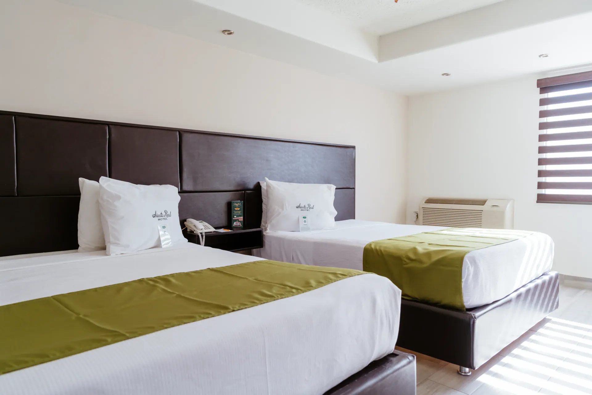 Una habitación de hotel con dos camas y una ventana.
