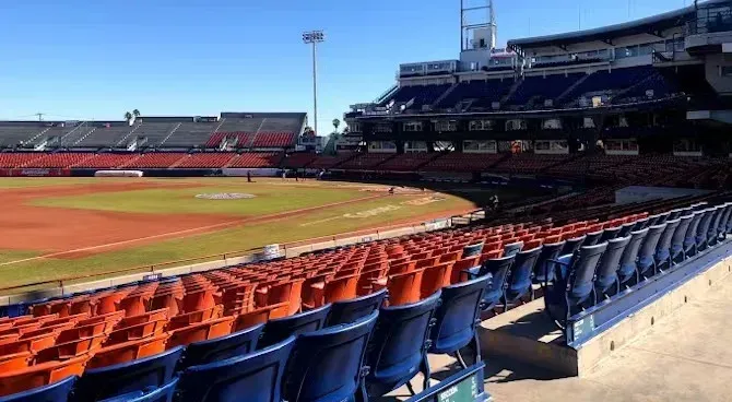 Filas de asientos vacíos en el estadio  el nido de béisbol  con un campo al fondo.