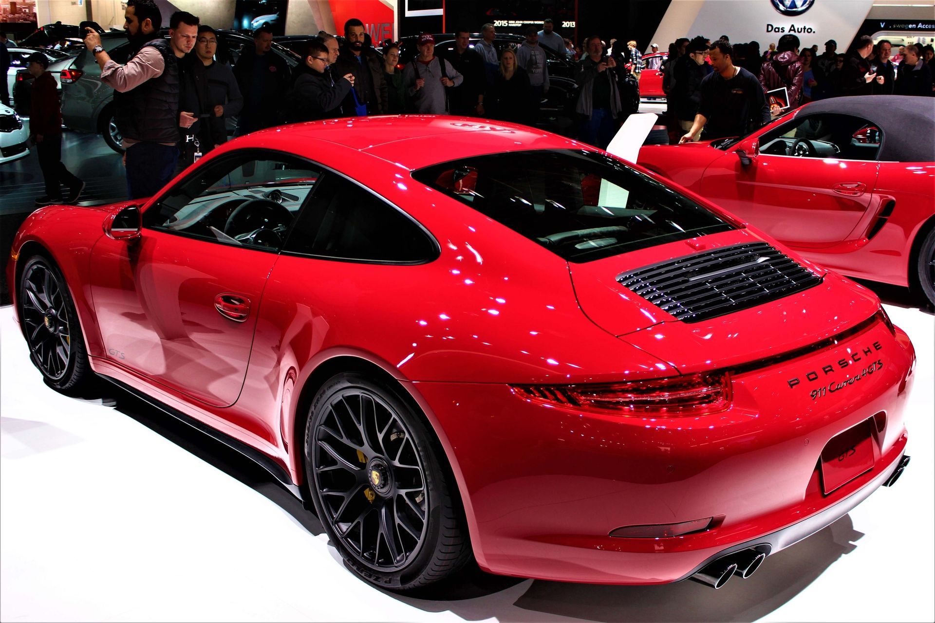 Ein schwarzer Porsche 911 Turbo Sportwagen, im Profil vor einem goldenen Sonnenuntergangshimmel geparkt.