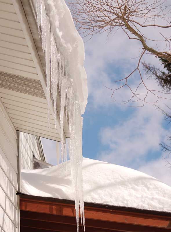 Damaged shingle roof with torn sections and exposed underlayment near the ridge