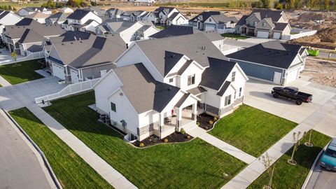 Aerial view of a suburban neighborhood with houses, roads, a pool, and desert hills in the background