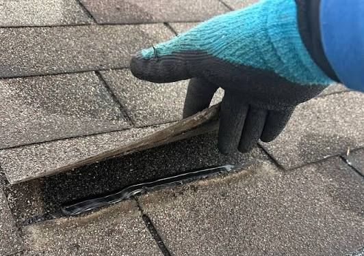 Close-up of gray roof shingles in rows, viewed from above.