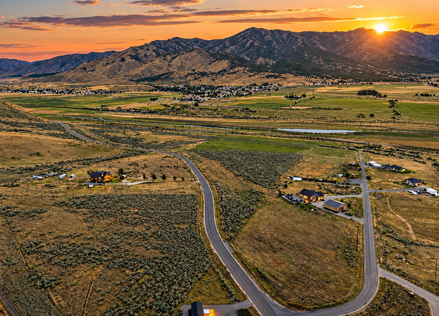 Aerial view of a suburban neighborhood with homes, trees, and mountains in the distance.