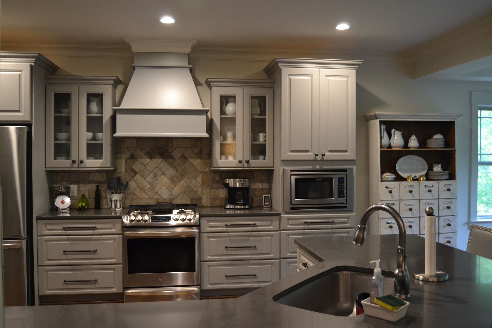 Gray kitchen with stainless steel appliances, cabinetry, and a dark countertop.