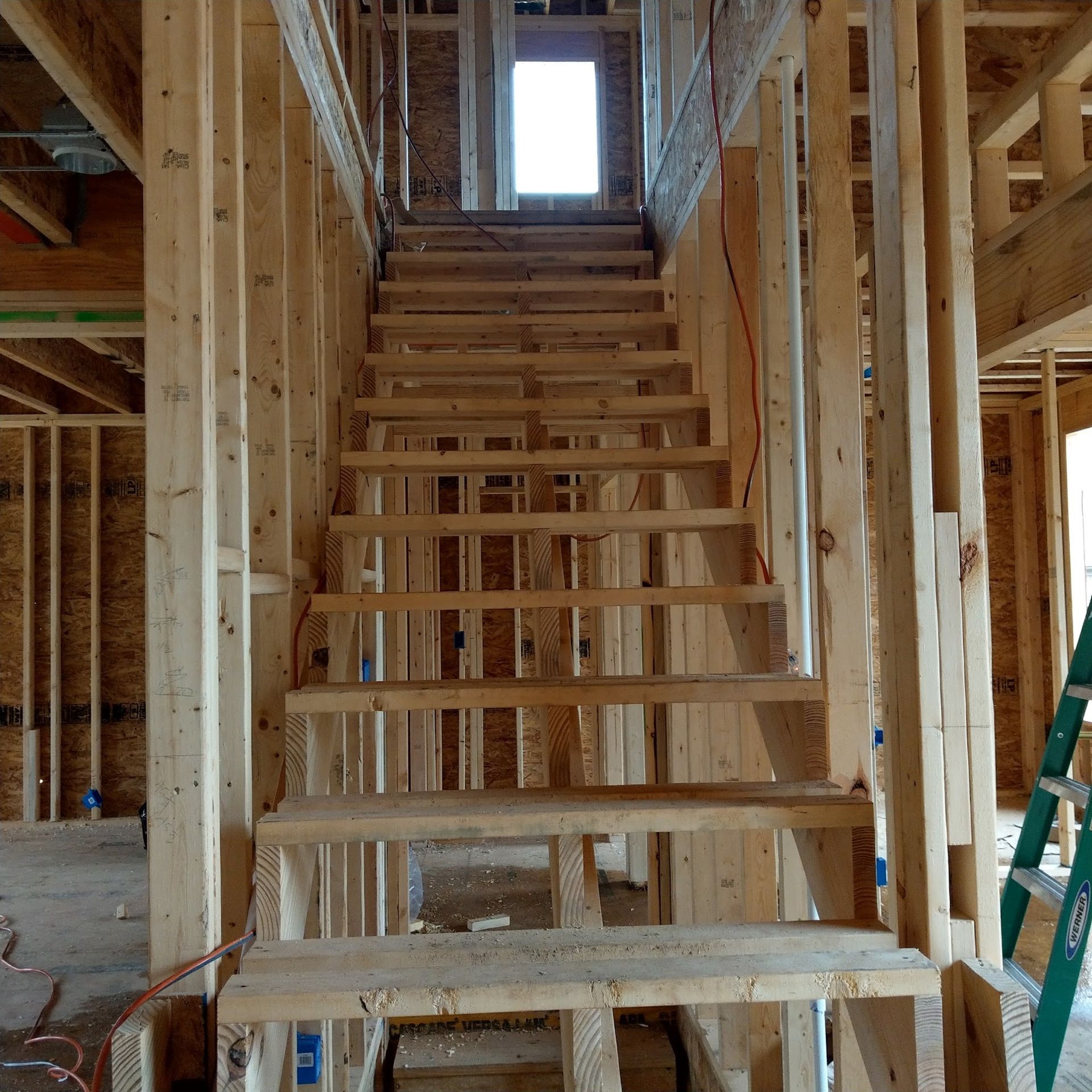 Interior view of unfinished wooden staircase. Construction site.