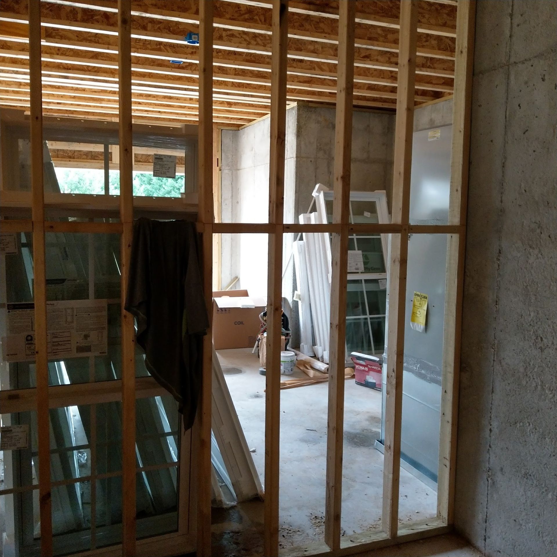 Interior view of a room under construction with wooden framing and concrete walls.