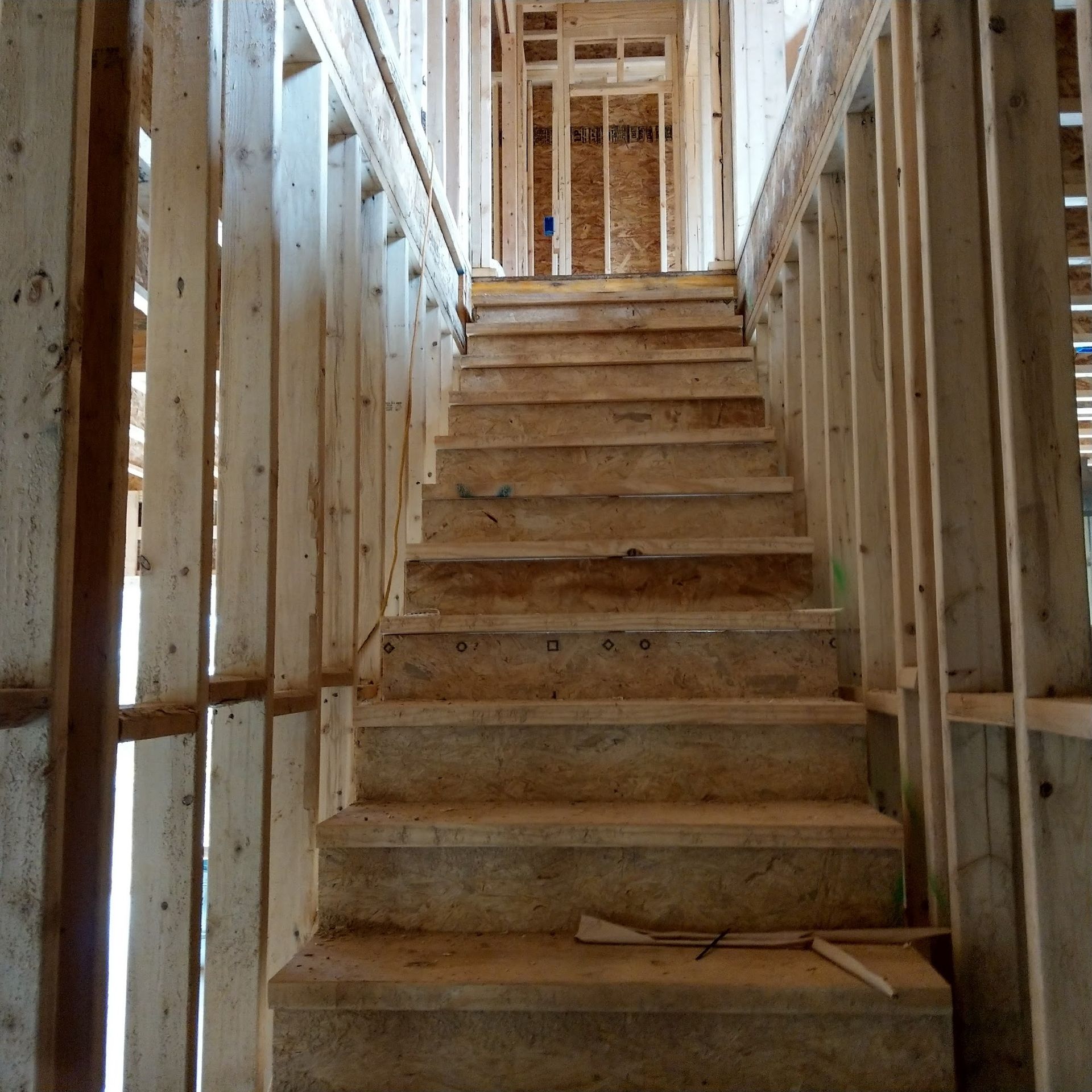 Unfinished wooden staircase inside a building under construction.