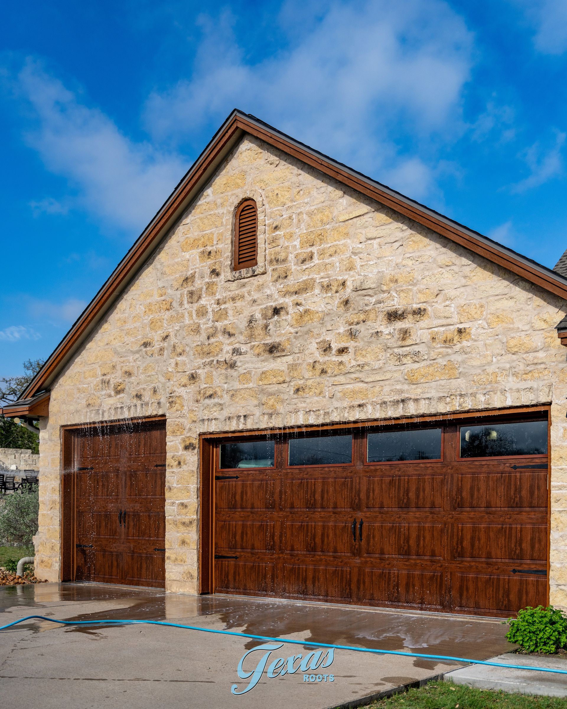 Garage stone exterior with algae staining before house wash Texas