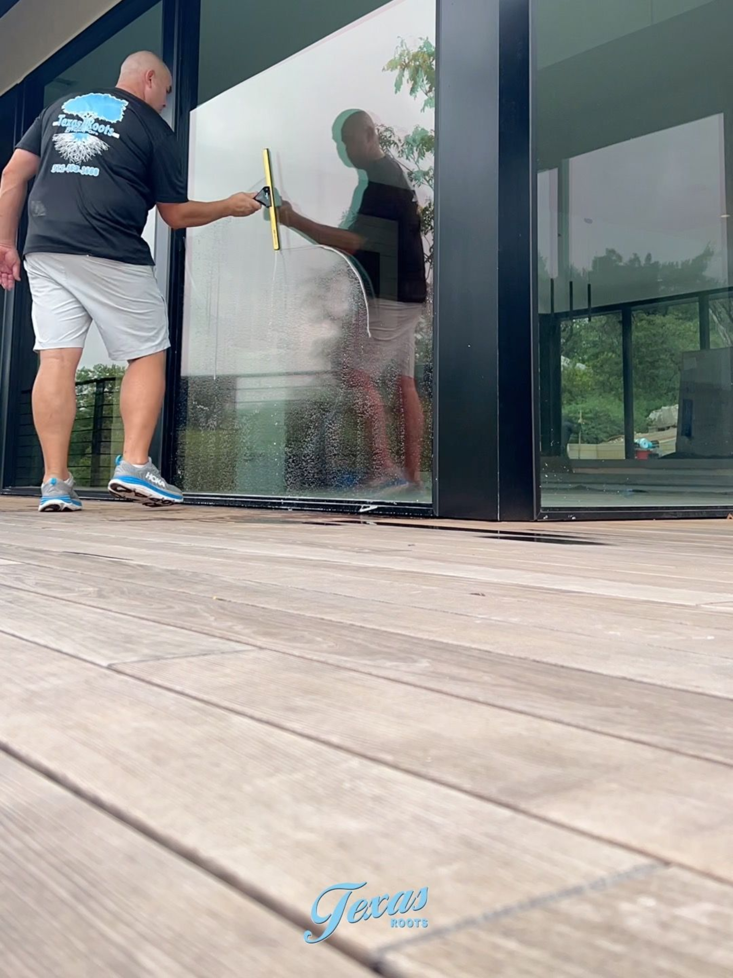     Exterior window cleaning with squeegee showing haze removal on modern home glass