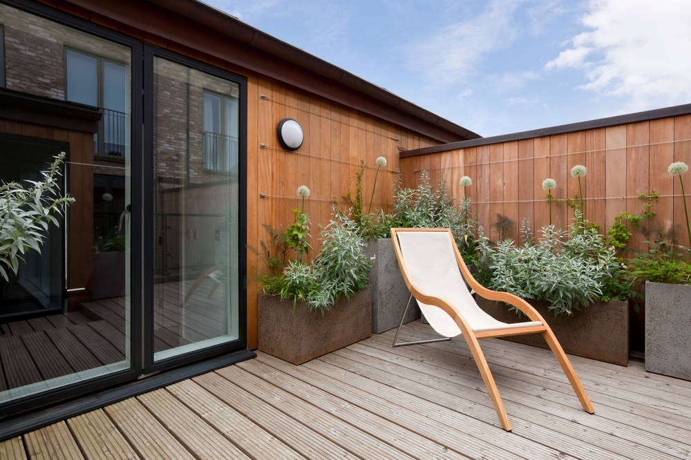Chair Sitting on Wooden Deck Next to Window | Buda, TX | Texas Roots Property Care