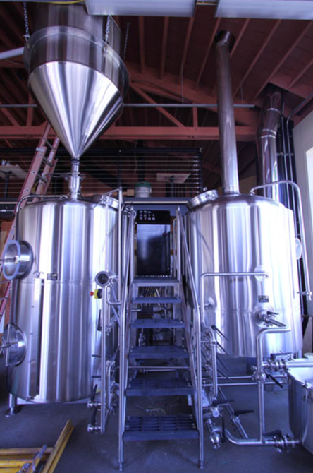 Stainless steel brewing tanks and pipes in an industrial brewery interior