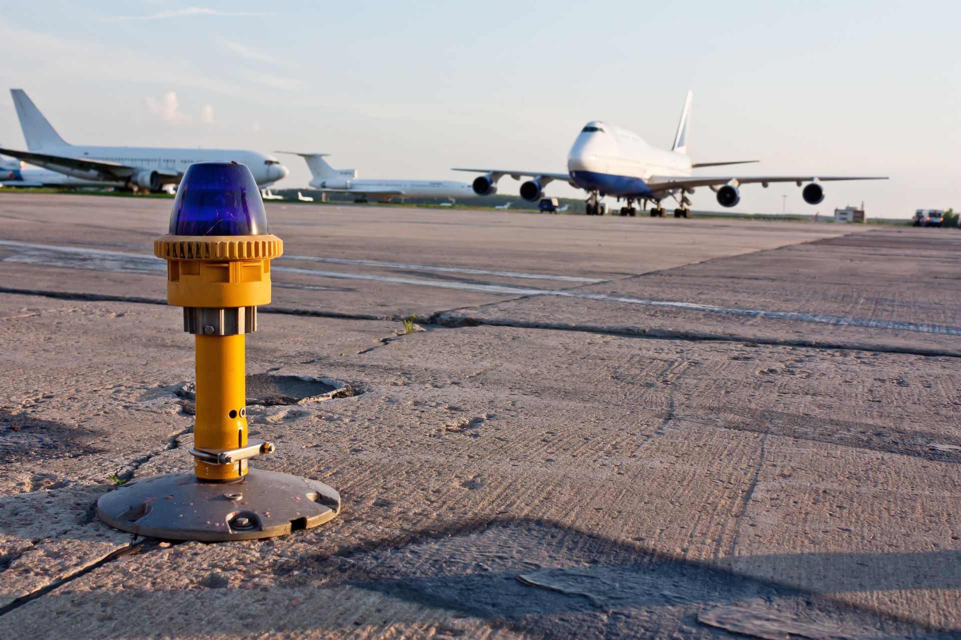Aircraft taxiing on runway with illuminated lights at airport during early evening hours. Aircraft taxiing on runway with illuminated lights at airport during early evening hours.
