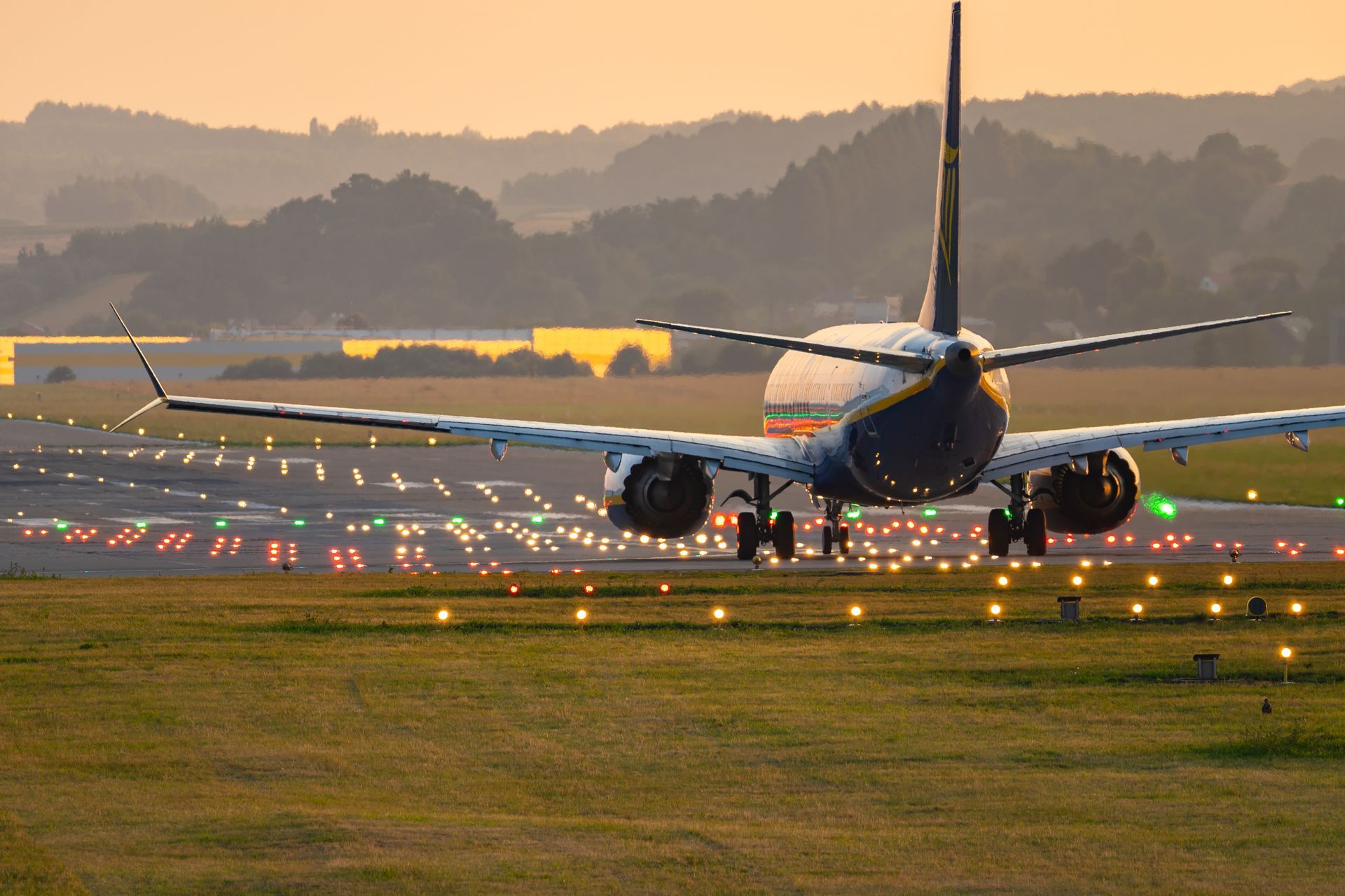 An airplane is landing on an illuminated runway.