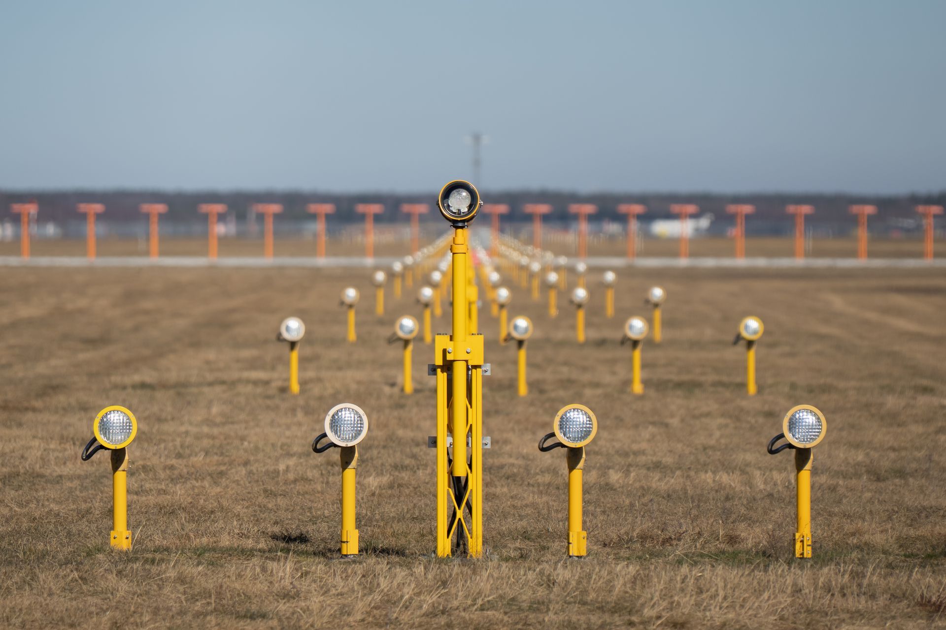 Runway approach lights in precise symmetrical alignment across an airport field. Runway approach lights in precise symmetrical alignment across an airport field.