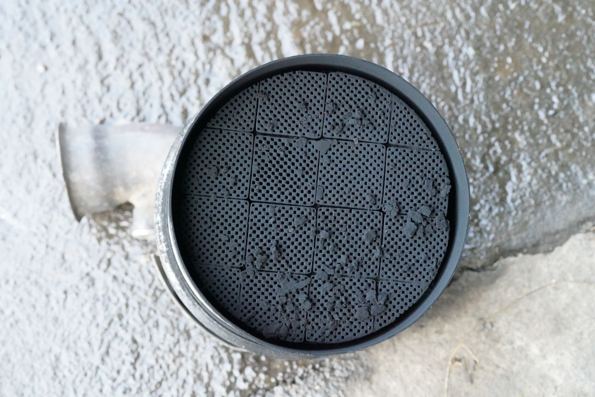 Circular filter on a textured white floor with a lot of soot Circular filter on a textured white floor with a lot of soot