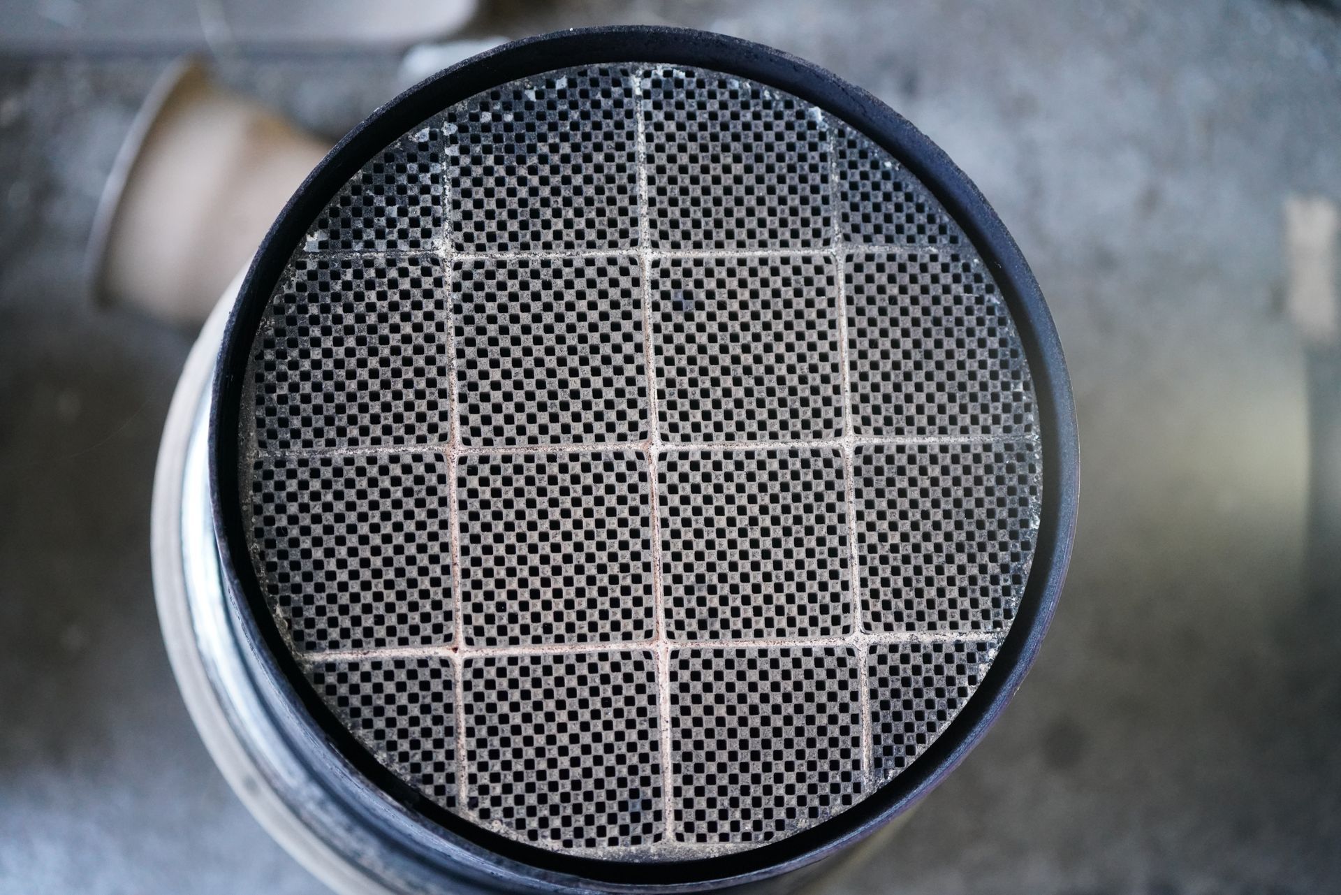 Close-up of a circular metal mesh filter with a grid pattern on a gray background Close-up of a circular metal mesh filter with a grid pattern on a gray background