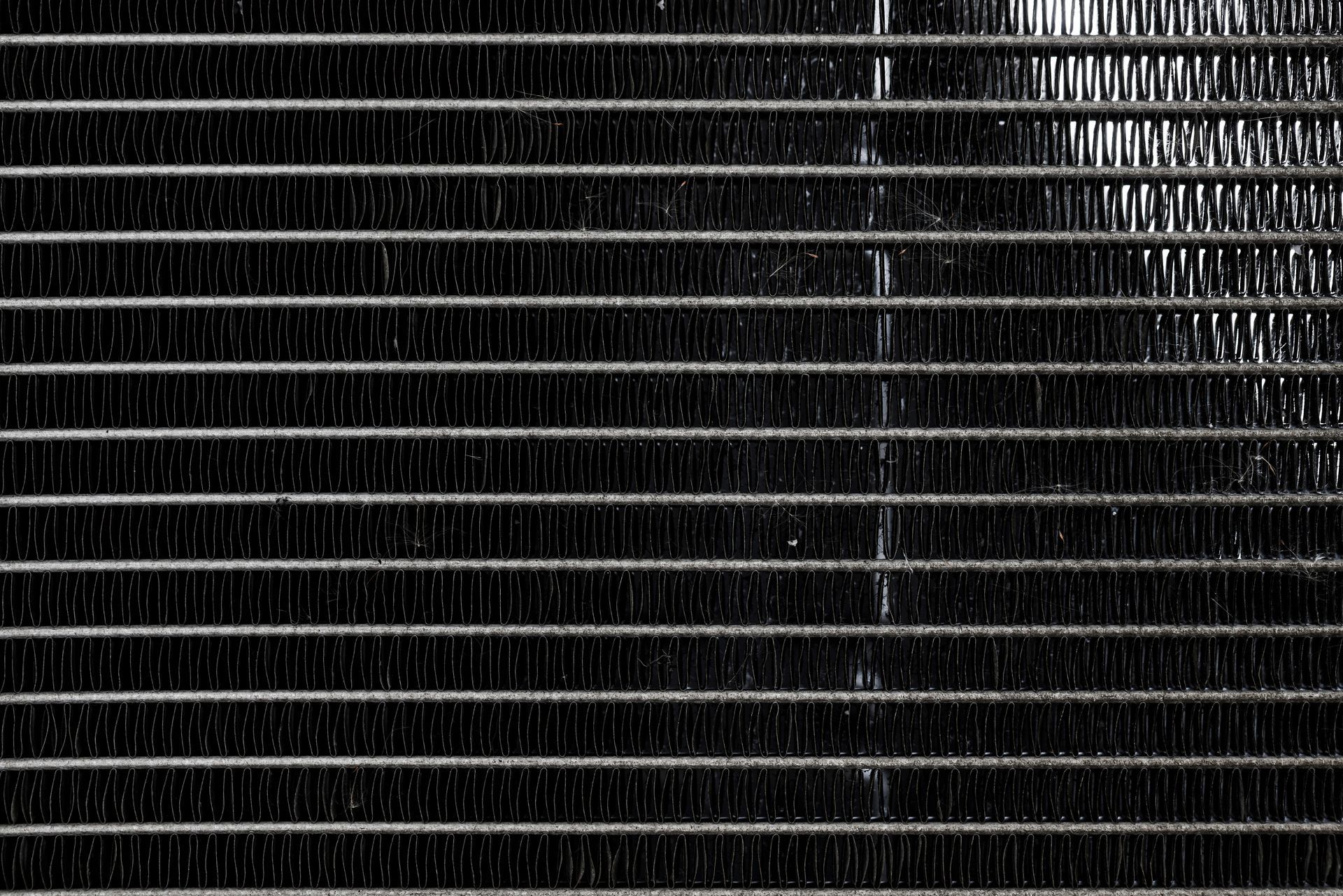 Black-and-white close-up of stacked horizontal metal slats or blinds with a textured right edge Black-and-white close-up of stacked horizontal metal slats or blinds with a textured right edge