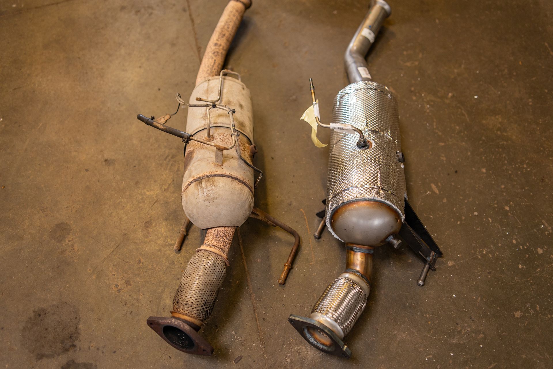 Two diesel particulate filters lying on a brown surface Two diesel particulate filters lying on a brown surface