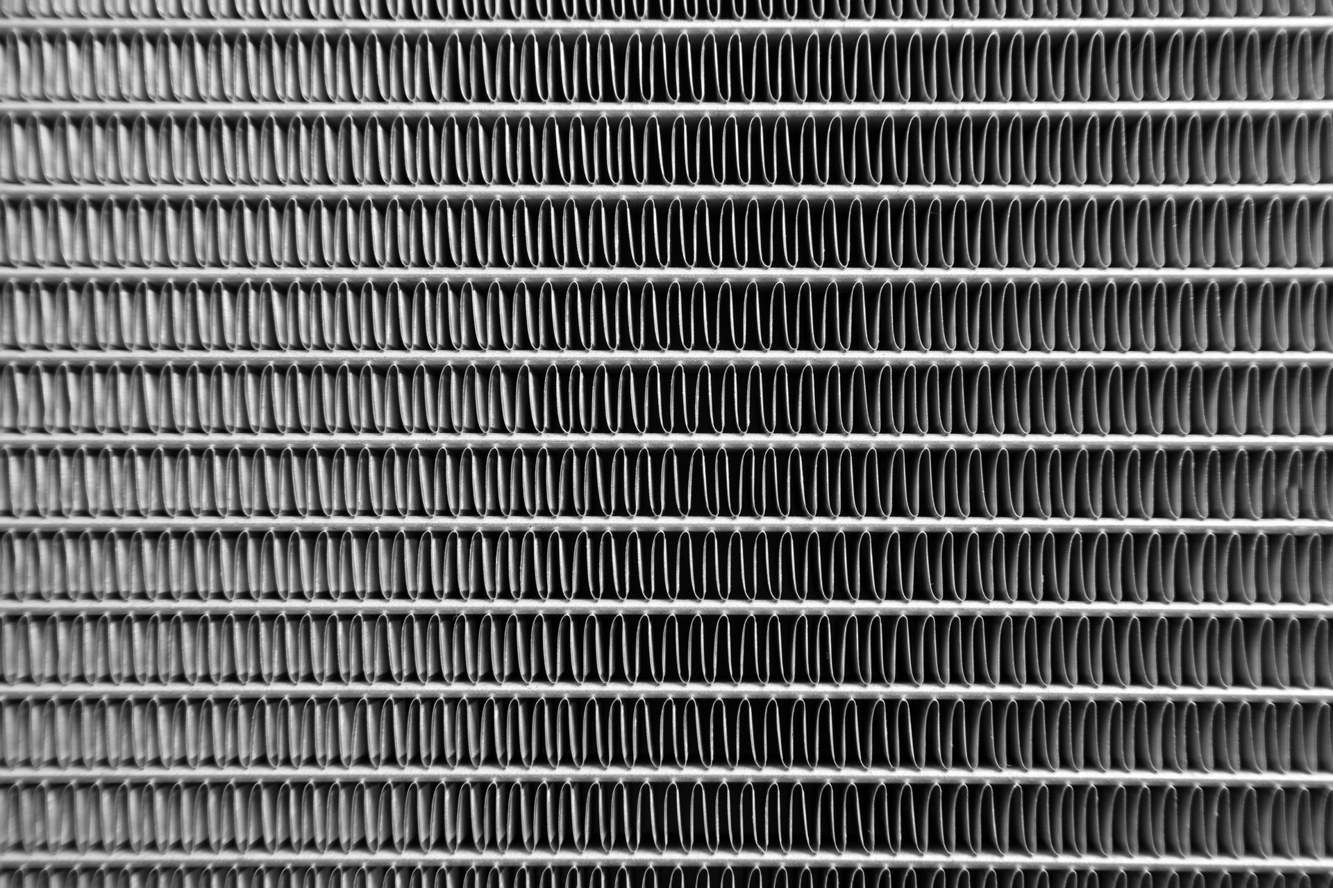 Close-up of a gray metal radiator grille with horizontal slats Close-up of a gray metal radiator grille with horizontal slats