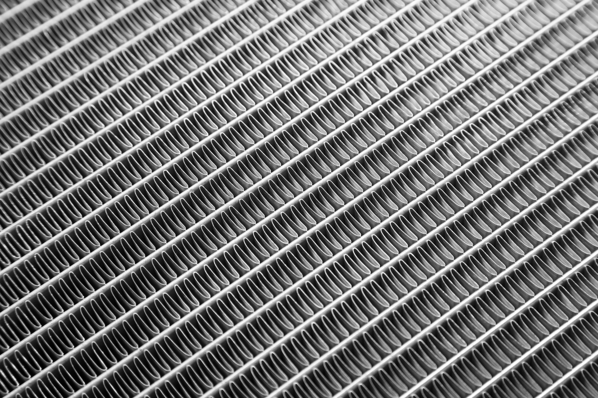 Diagonal view of a metallic mesh or grille with repeating diagonal lines Diagonal view of a metallic mesh or grille with repeating diagonal lines