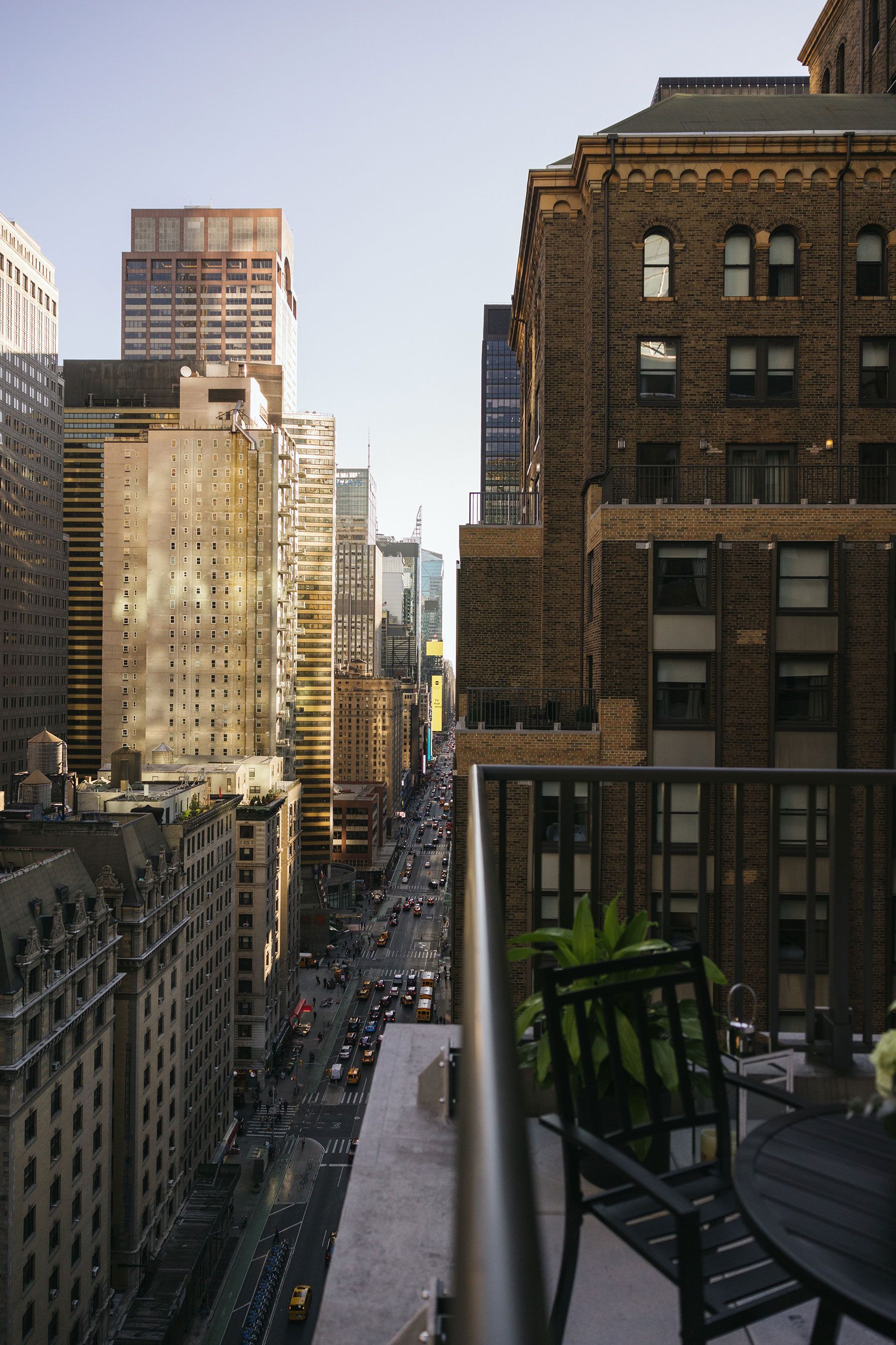 A balcony with a table and chairs overlooking a city street