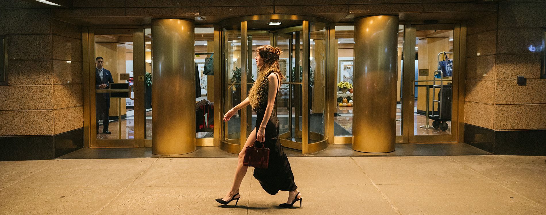 a revolving door with a woman walking in front of it