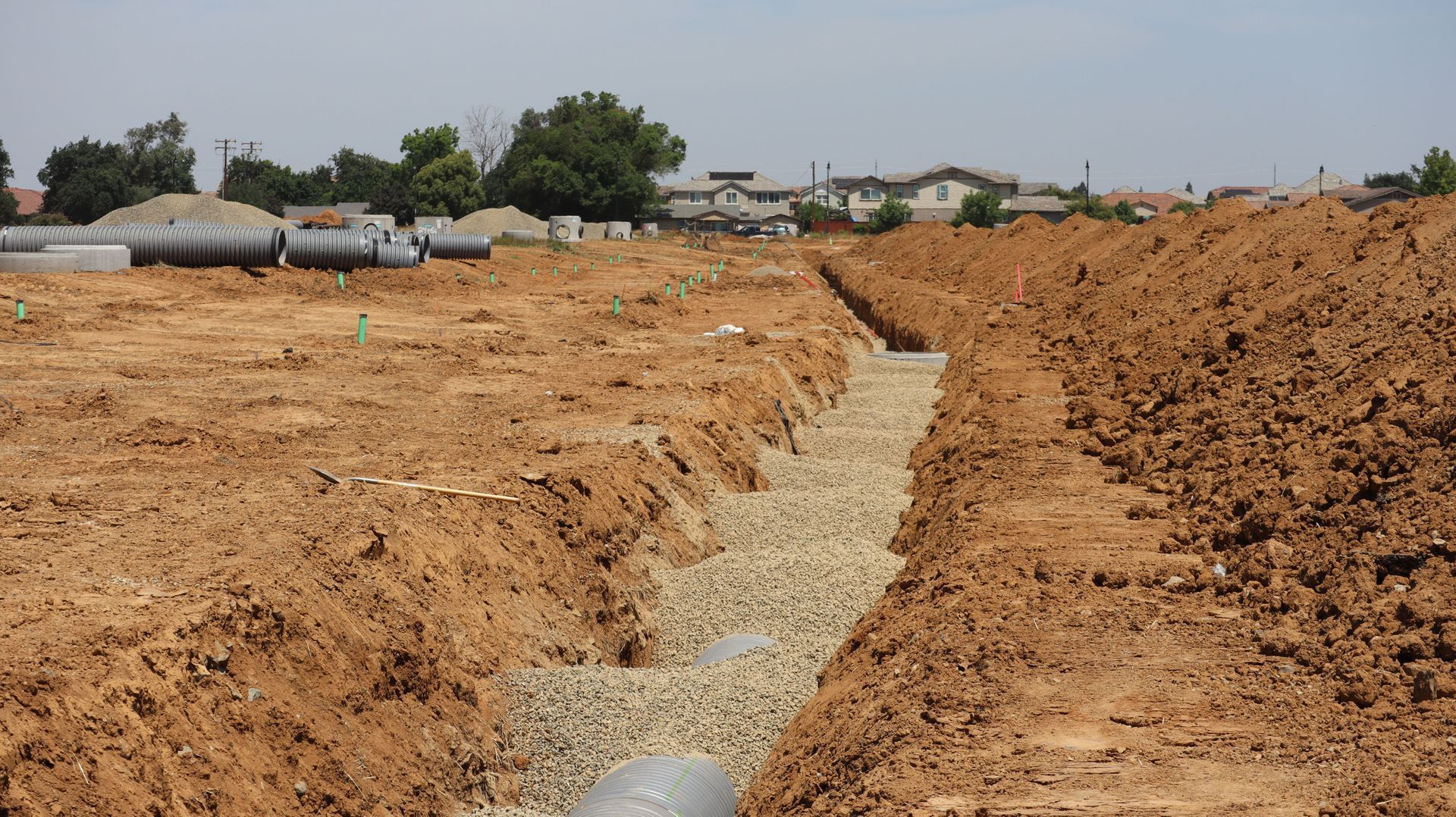 Yellow bulldozer pushing dirt at a construction site with rubble and mounds of soil