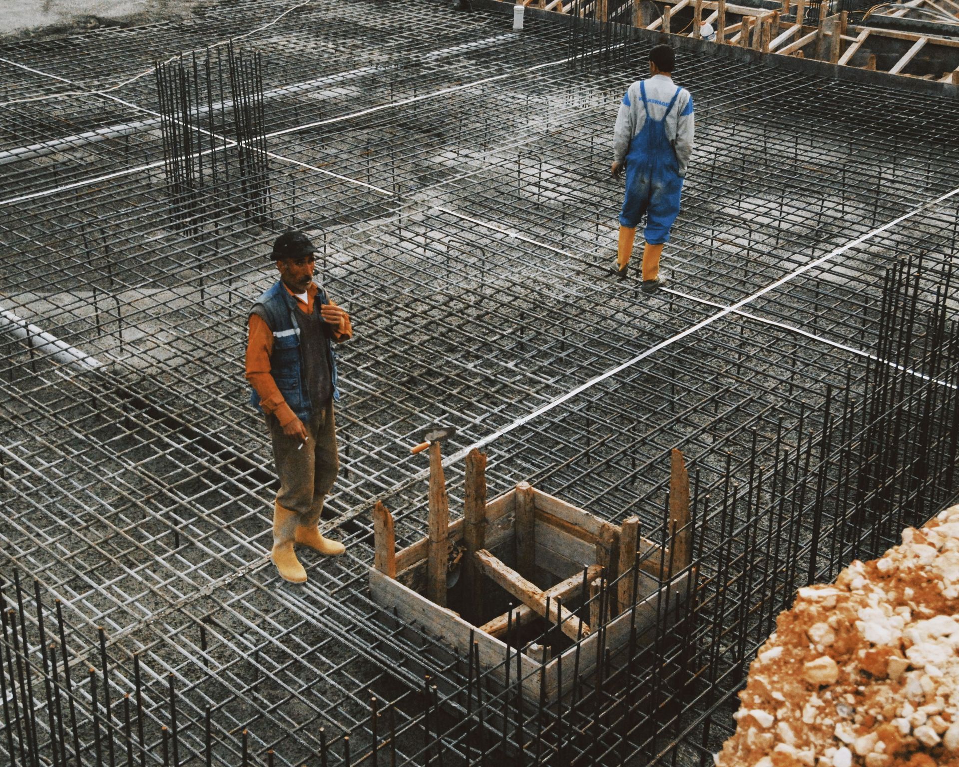 Yellow bulldozer pushing dirt at a construction site with rubble and mounds of soil