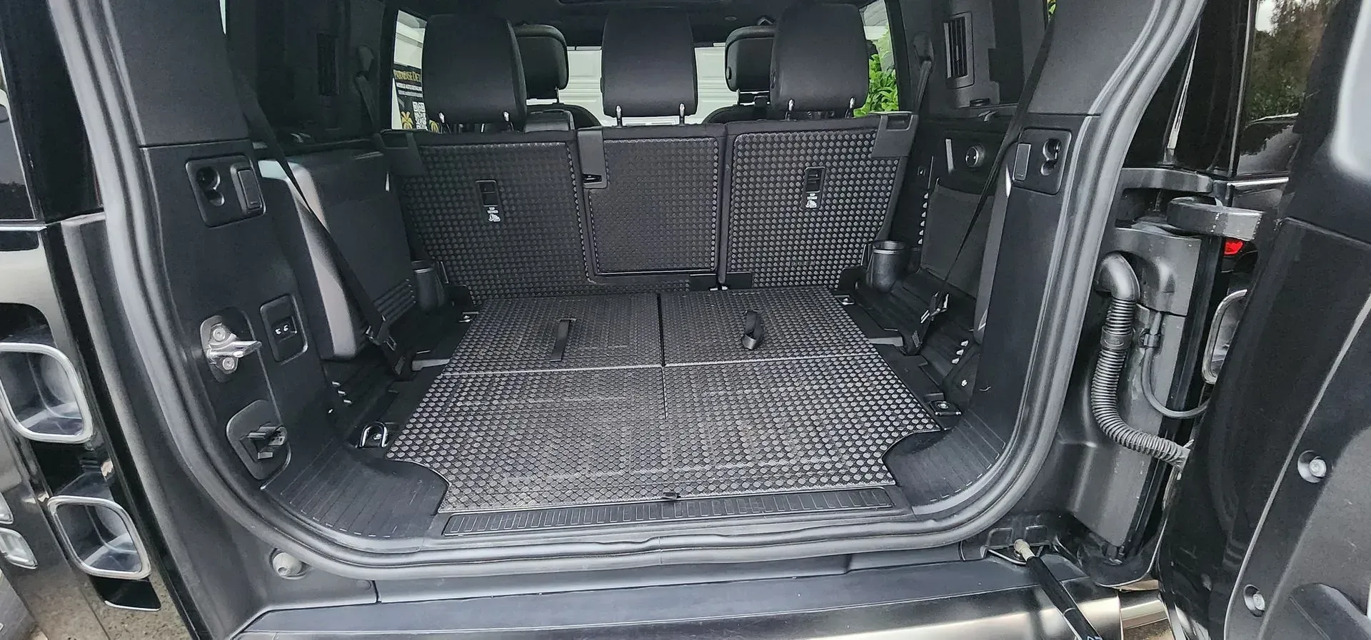 Car cargo area with folded-down rear seats and a protective floor mat