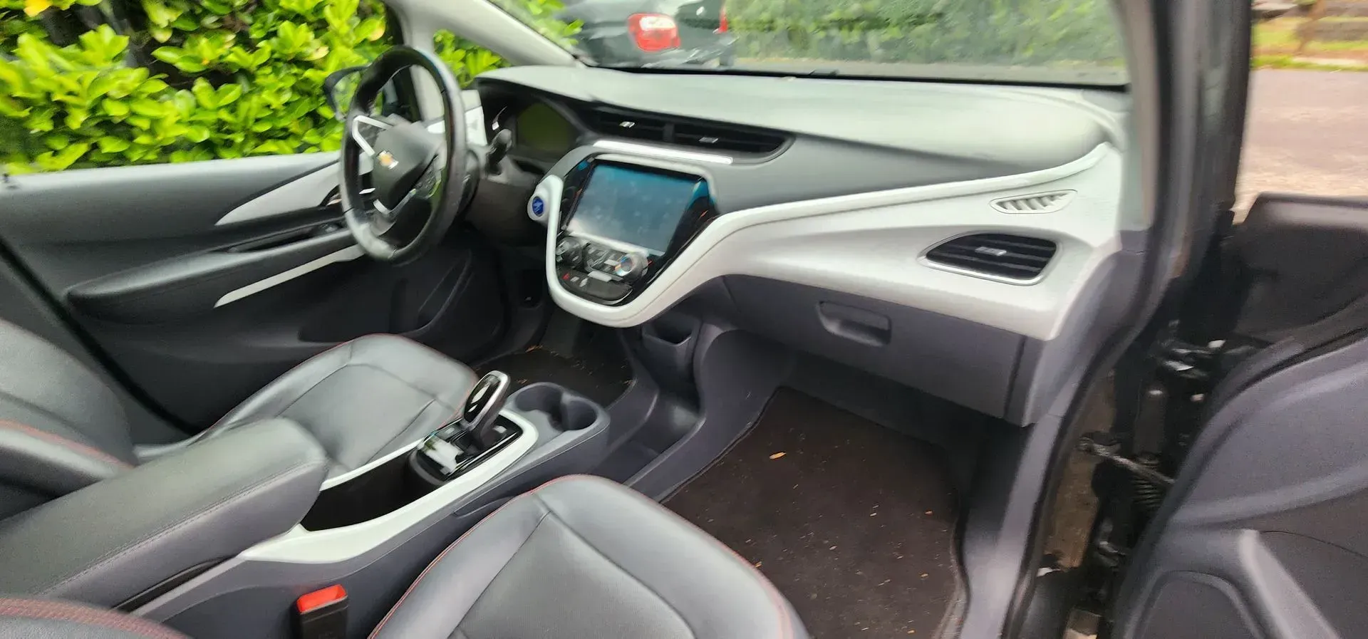 Car interior with black seats, dashboard, and center console viewed from the front passenger side.