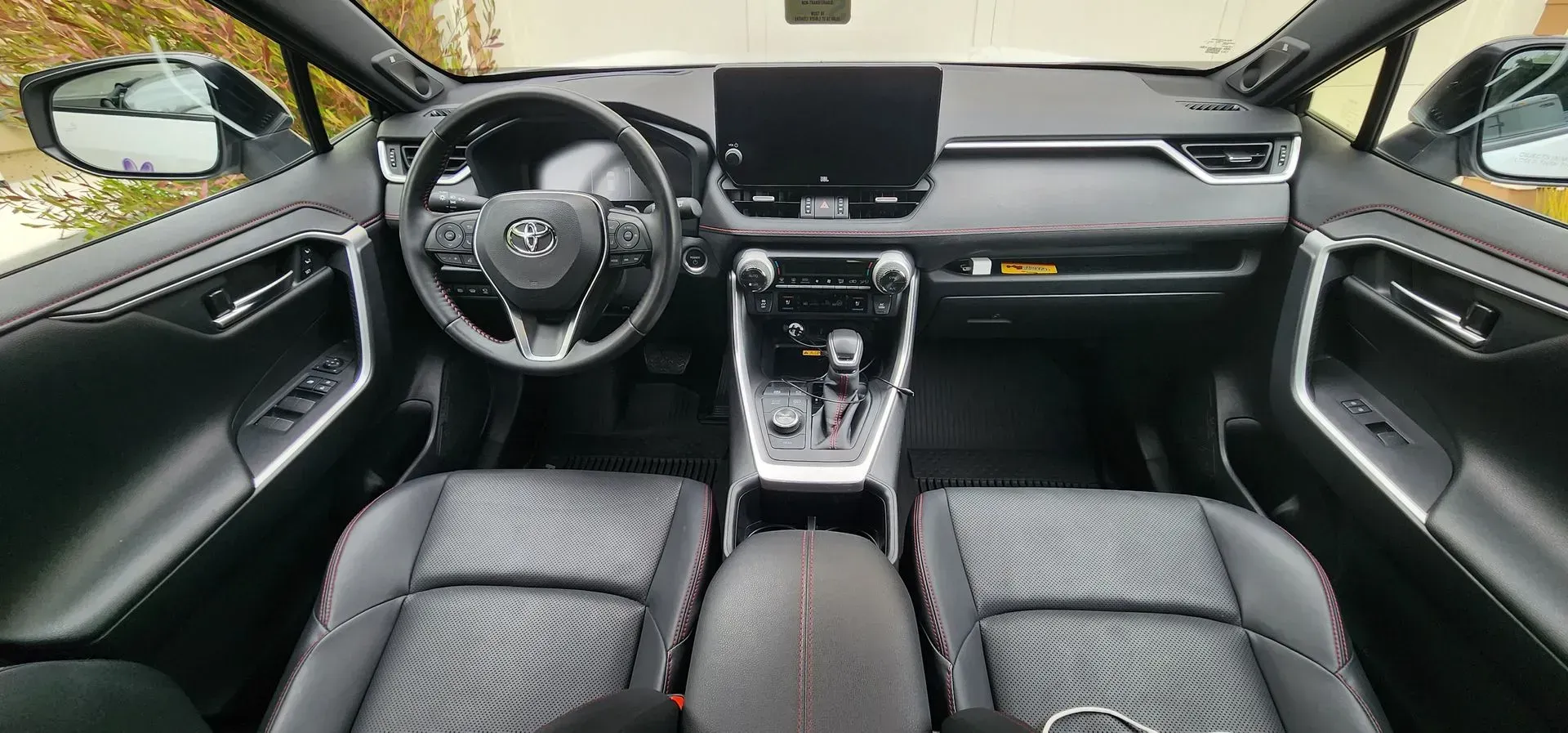 Modern car interior with black leather seats, steering wheel, dashboard, and center console