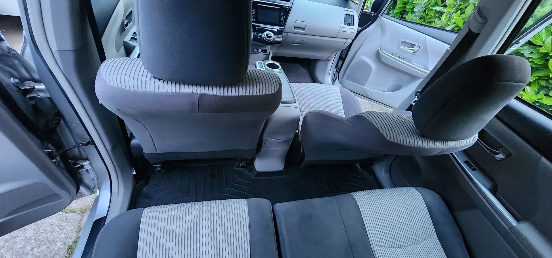 Car interior with gray-and-black seats, visible center console, and rear bench seat viewed from the back