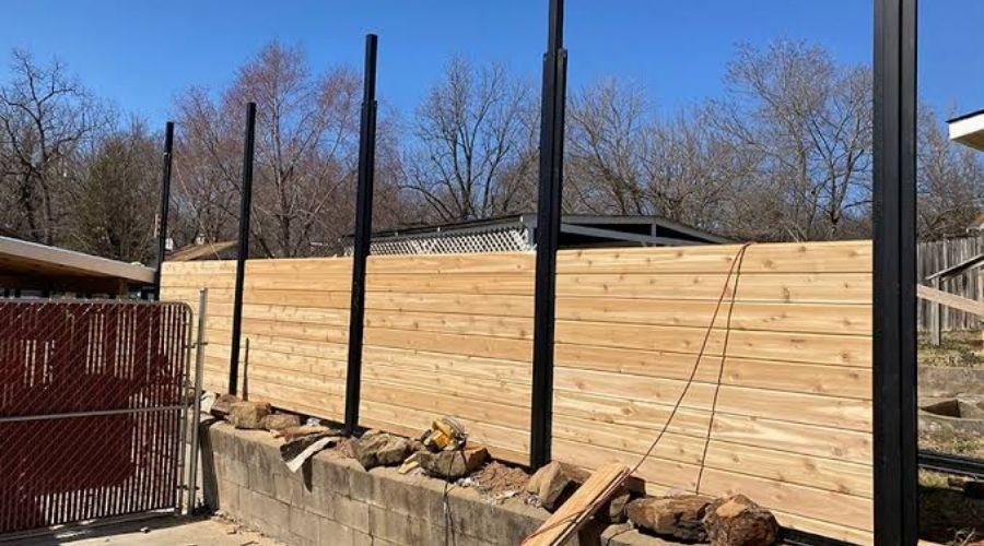 Horizontal wood fence installation using sturdy metal posts set below the frost line in Minnesota.