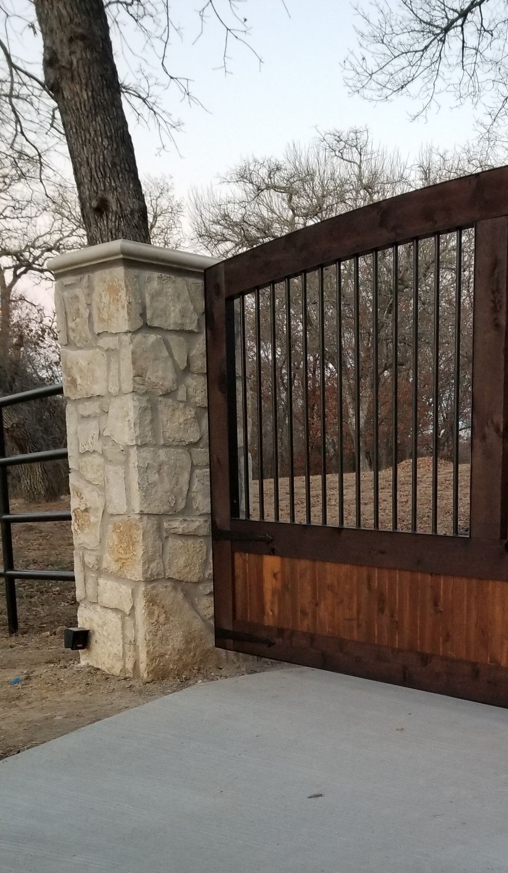 Custom wood automated gate with Stone Columns