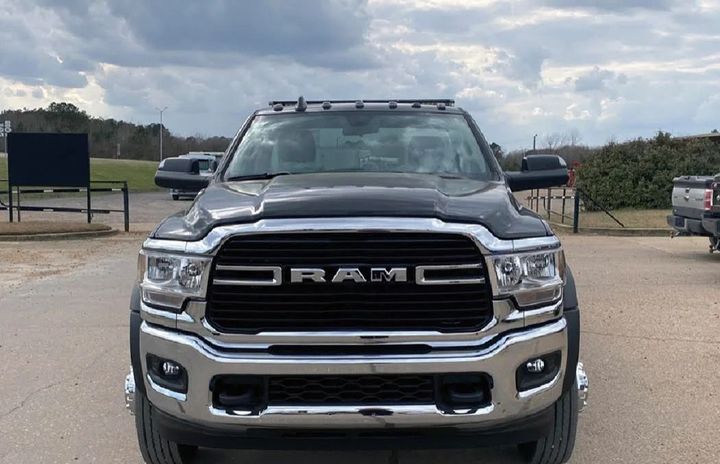 Front view of a black RAM pickup truck parked outdoors on a dirt lot