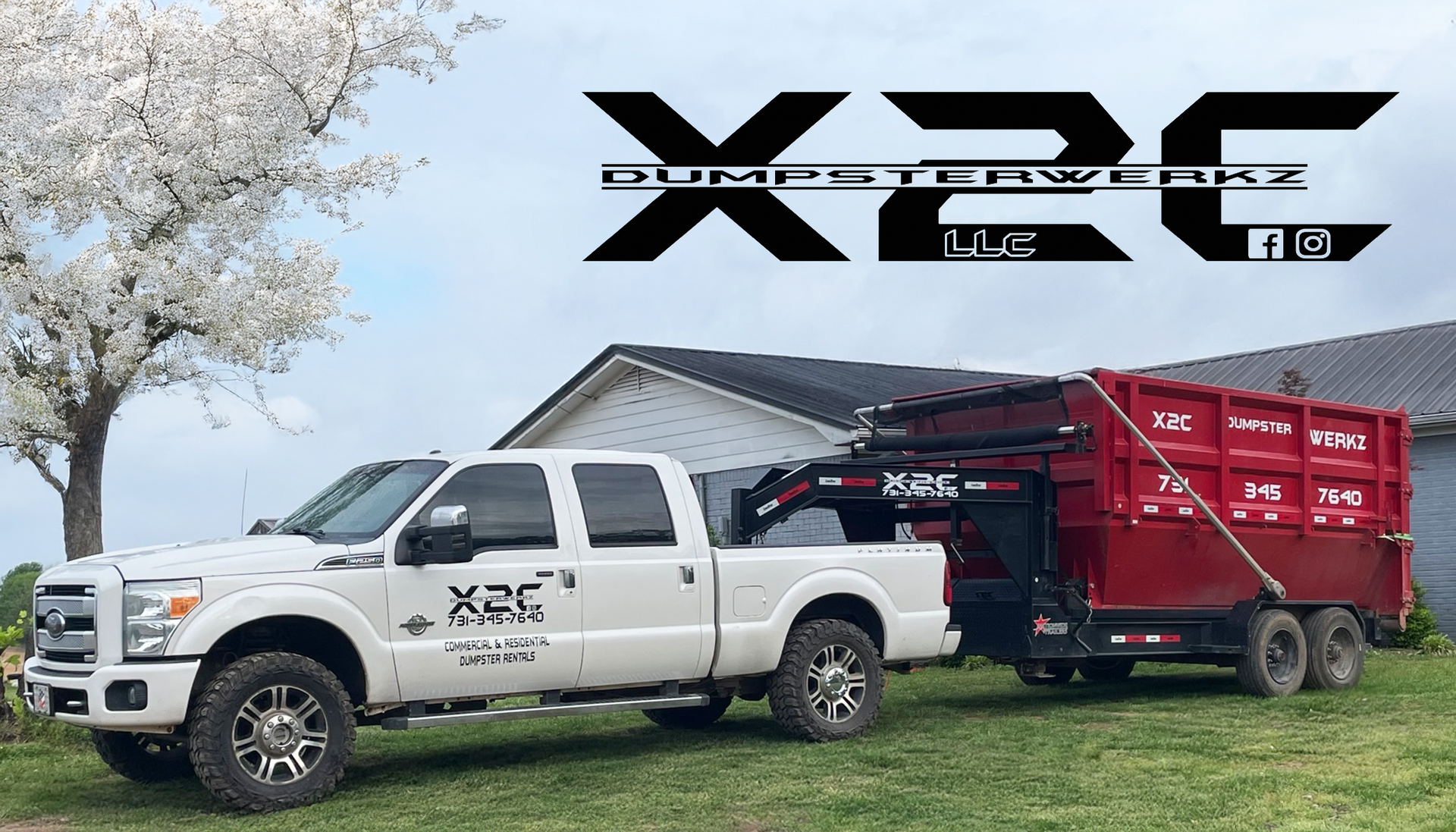 White pickup truck towing a red XPC dump trailer in a grassy yard with a house and tree in the background