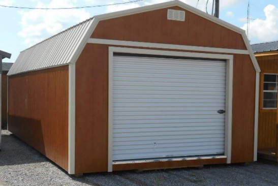 Brown and white shed with a white roll-up garage door under a metal curved roof.