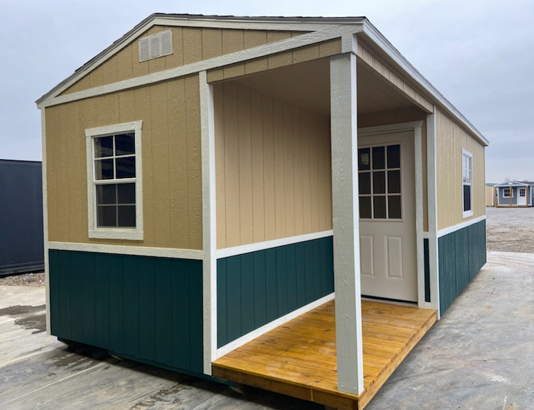 Tan and teal shed with porch and window.