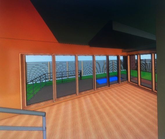 A computer-rendered indoor room with wood flooring, orange walls, and large floor-to-ceiling windows overlooking a patio.
