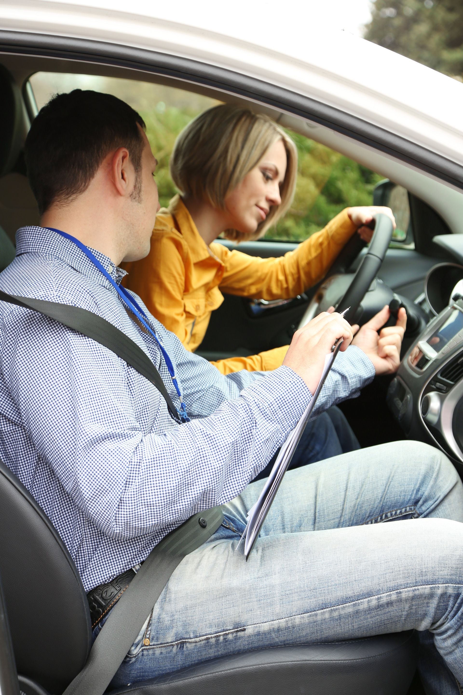 Learner driver student driving car with instructor.