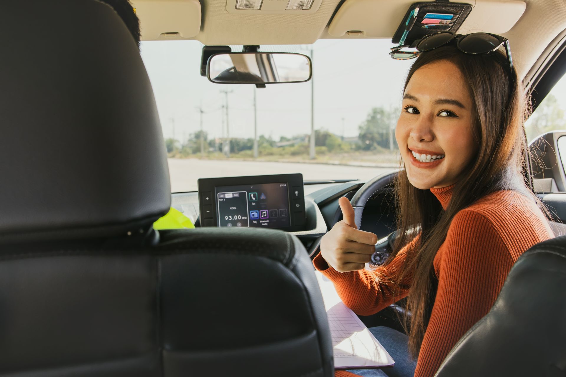 Teach driving : Beautiful young asian beginner preparing to learn driving taught by expert instructors from driving school to drive on roads safely thumbs up to great teaching and driving lessons.