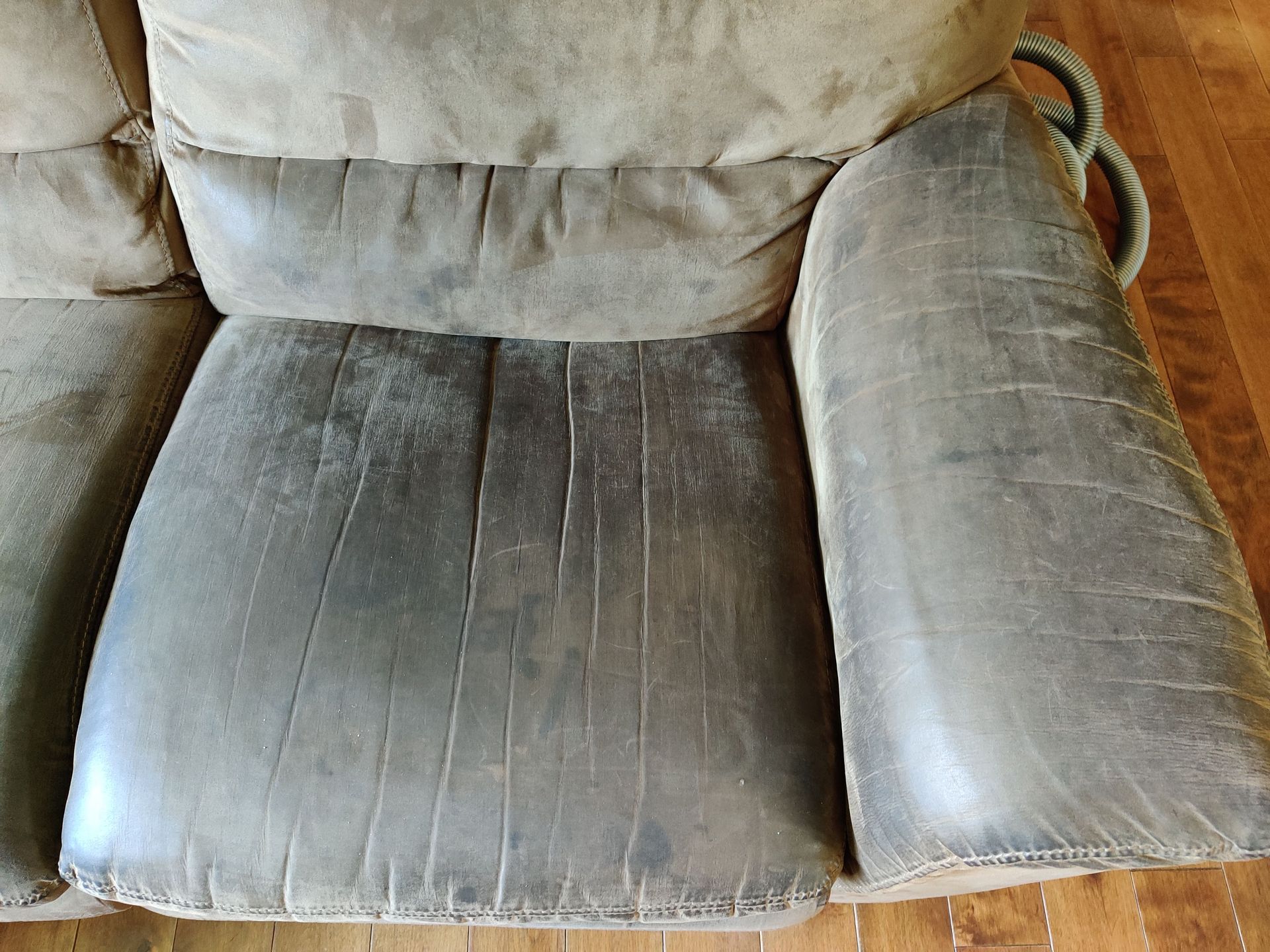 Un fauteuil inclinable en cuir sale est posé sur un plancher en bois.