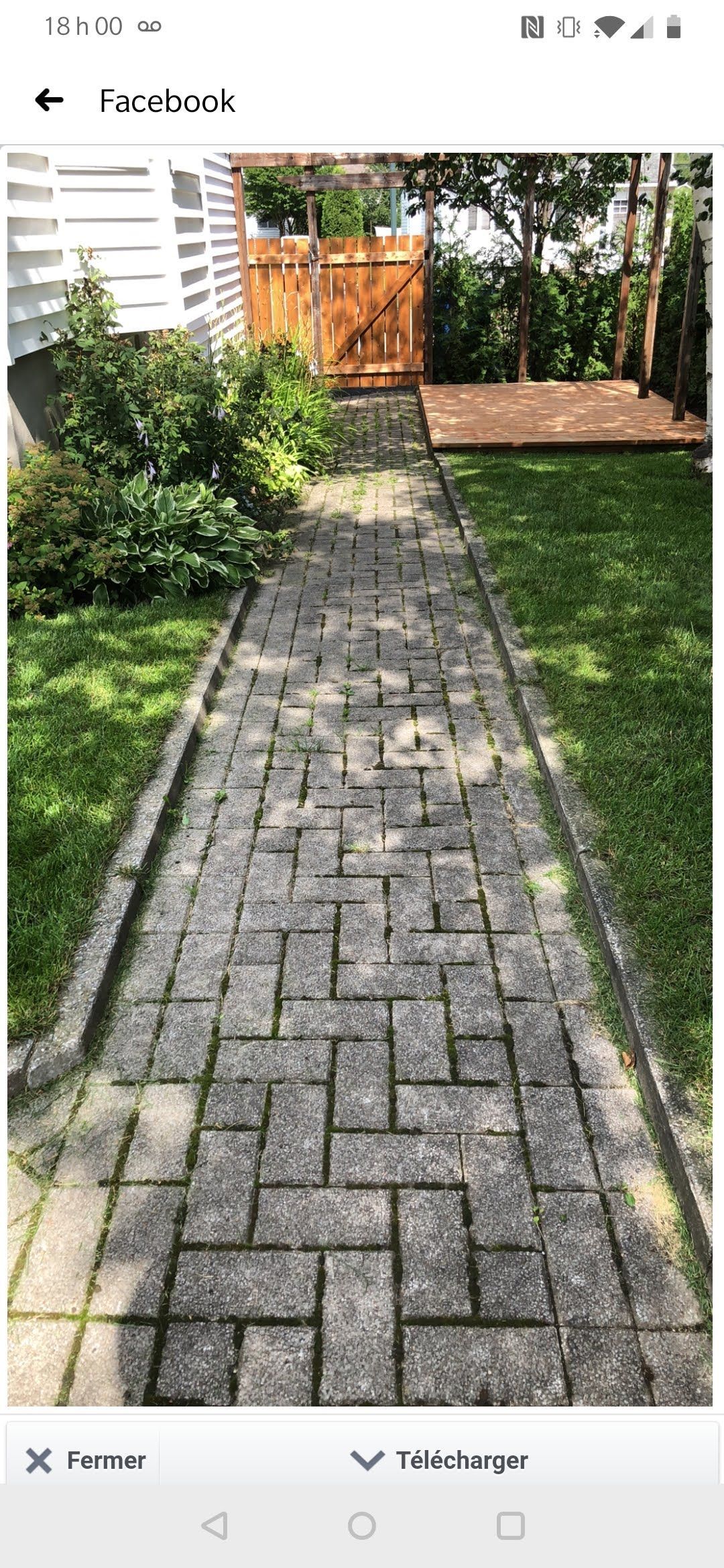 Une photo d'une allée en briques menant à une cour.