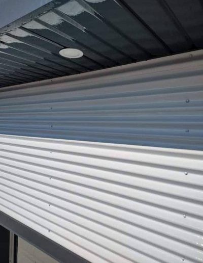 Un gros plan d'un toit en métal blanc avec un ciel bleu en arrière-plan.