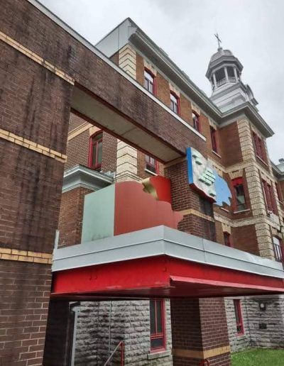Un grand bâtiment en briques avec un panneau bleu qui dit paix